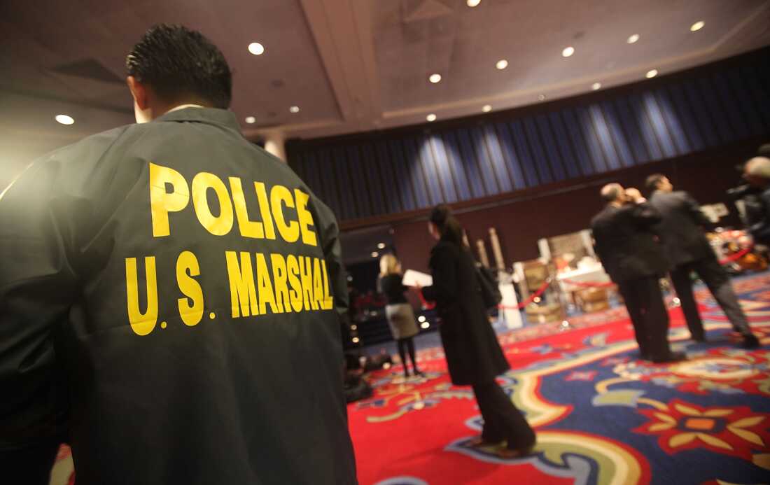 A U.S. Marshal looks on an auction in 2009 in New York City.