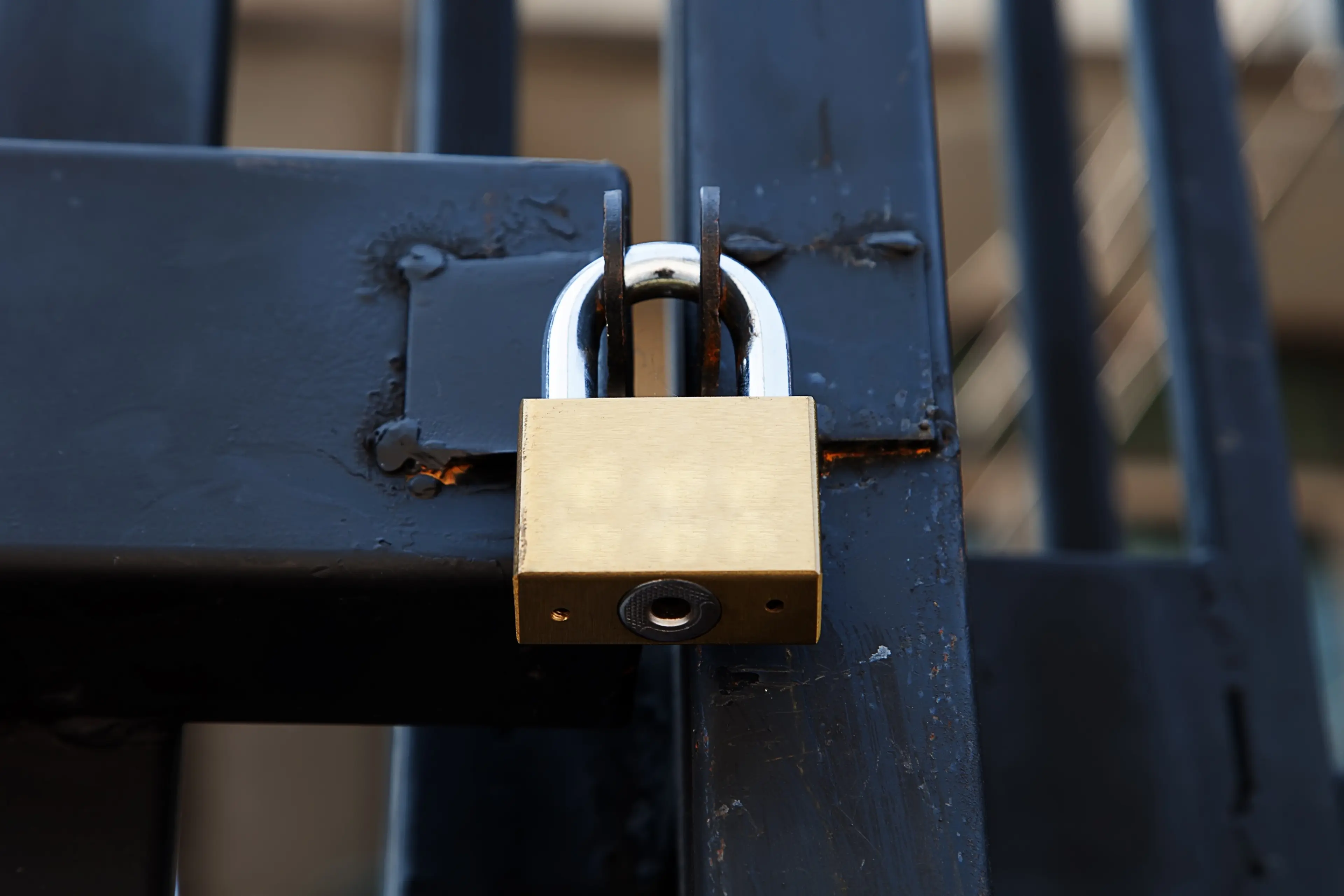 A padlock secures a gate hasp. (Shutterstock)